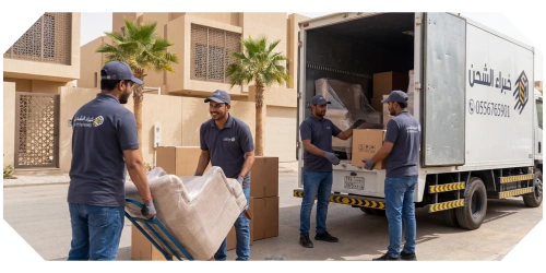فريق عمل مدرب يقوم بتحميل قطع الأثاث الكبيرة والمغلفة إلى شاحنة نقل في الرياض