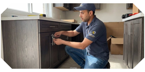 فني متخصص يثبت أثاث المطبخ أو خزانة، ضمن خدمات نقل وتركيب الأثاث بالرياض